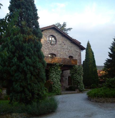 a large stone building with a balcony and a window at Jardin de Carrejo in Cabezón de la Sal