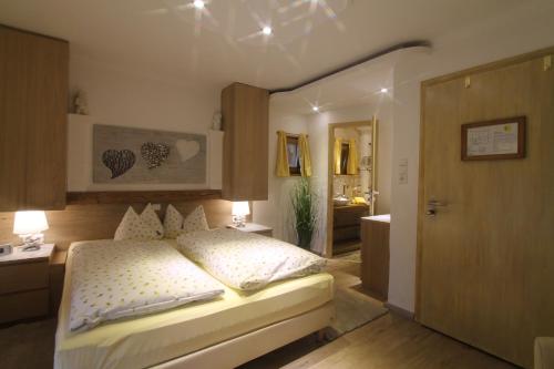 a bedroom with a large bed and a bathroom at Haus Sonnenschein in Grainau