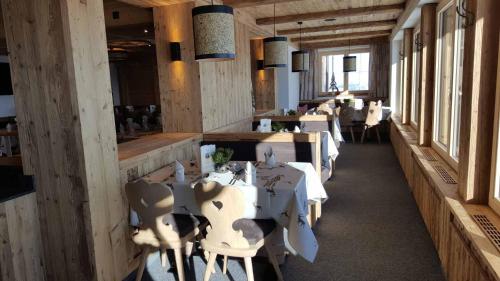 a restaurant with white tables and chairs in a room at Berggasthof Schatzbergalm in Thierbach