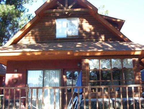 Cabaña de madera con ventanas en un porche en Casa Pucon - Condominio Doña Augusta, en Pucón