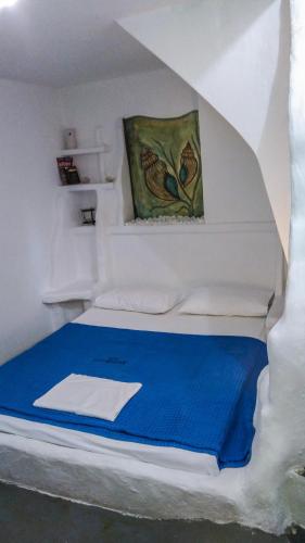 a white bedroom with a bed with blue sheets at Giannakas Studios in Platis Yialos Sifnos