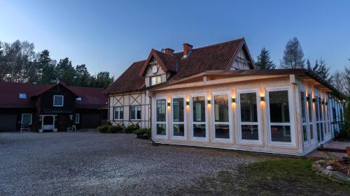 a house with a conservatory with lights on it at Willa Stodoła in Miłomłyn