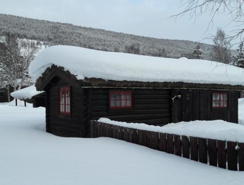 a log cabin with snow on the roof at Weistad in Heidal