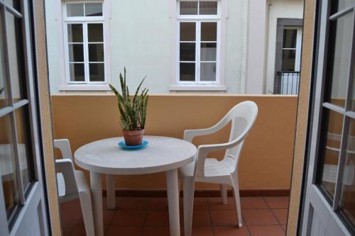 フンシャルにあるCentral Suite in Funchal 3Nのバルコニー(テーブル、椅子2脚、鉢植えの植物付)