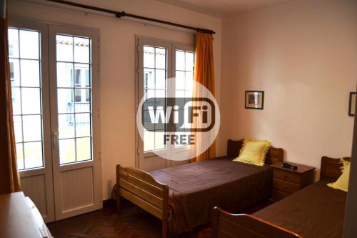 una camera con un letto e due finestre e una porta di Central Suite in Funchal 3N a Funchal