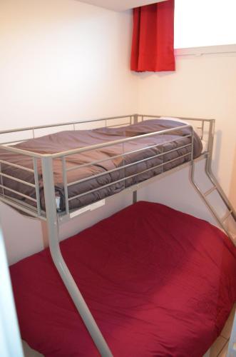 Ce lit superposé se trouve dans un dortoir doté d'un matelas rouge. dans l'établissement Appart vue sur port, à Boulogne-sur-Mer