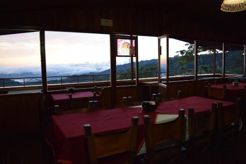 a dining room table with chairs and umbrellas at Mirador Valle del General in La Ese