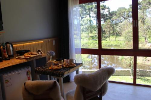una cocina con una mesa con comida y una ventana en Pousada dos Cataventos, en São Francisco de Paula