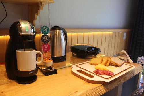 een tafel met een koffiezetapparaat en een bord eten bij Pousada dos Cataventos in São Francisco de Paula