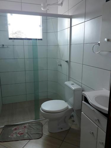 a white bathroom with a toilet and a sink at Apartamentos de Penha in Penha