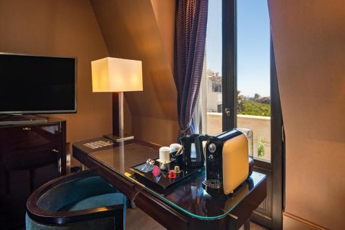 a hotel room with a desk with a telephone and a window at Hotel Casa Fuster G.L Monumento in Barcelona