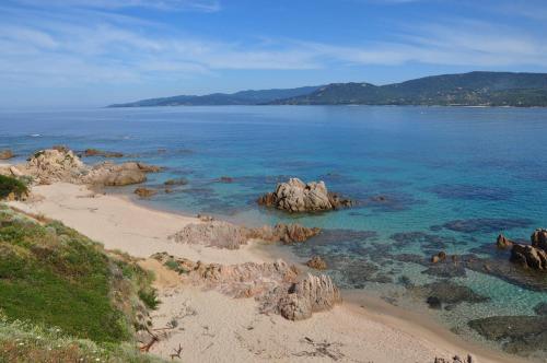 a view of a beach with rocks in the water at Lecci e Murta in Propriano