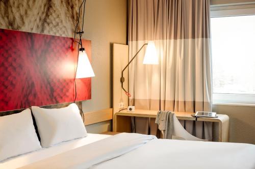 una camera d'albergo con letto e finestra di ibis Zürich Messe Airport a Zurigo