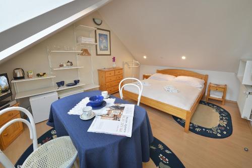 a bedroom with a bed and a table with a blue table cloth at A. V. Pension Praha in Prague