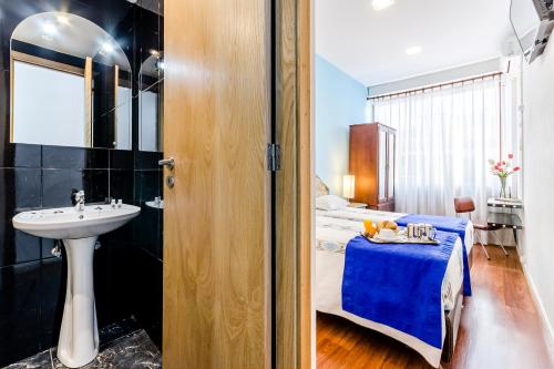 un bagno con lavandino e un letto in una camera di Santa Clara Porto a Porto
