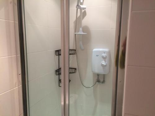 y baño con ducha y puerta de cristal. en 16 East Street Sandwick Stornoway, en Sandwick