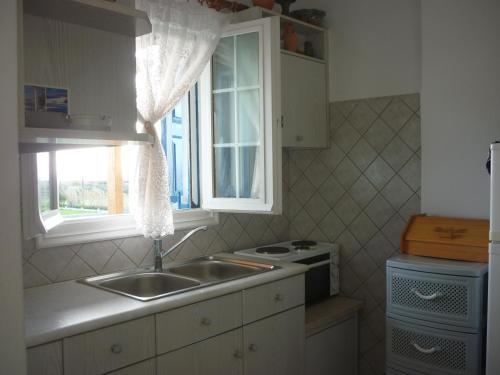 a kitchen with a sink and a window at Joanna Apartments in Mikri Vigla