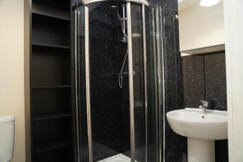 a bathroom with a glass shower and a sink at Spacious Home Dundee in Dundee