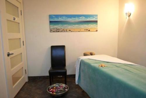 a bedroom with a bed and a chair and a painting at Lunenburg Arms Hotel in Lunenburg
