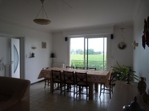 une salle à manger avec une table et des chaises et une fenêtre dans l'établissement Gite La Rizière, à Vic-en-Bigorre