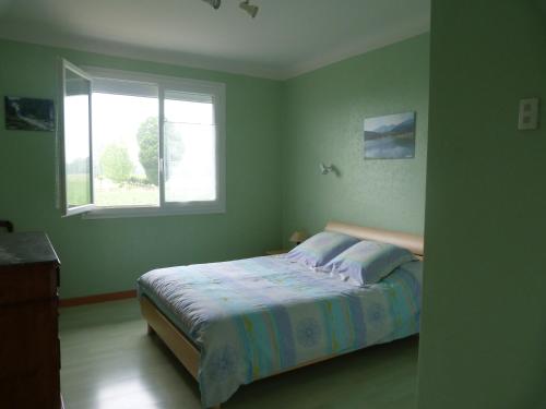 a bedroom with a bed and a window at Gite La Rizière in Vic-en-Bigorre