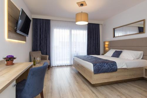 a hotel room with a bed and a table and a desk at B&B Villa Maris Punat in Punat