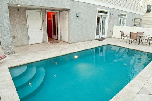 uma piscina azul em frente a uma casa em DeSoto Beach Vacation Properties em Tybee Island