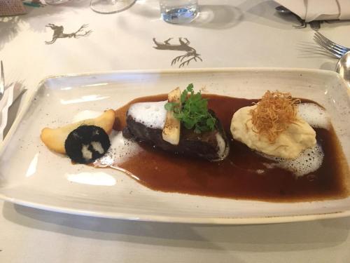 a white plate of food on a table at Berggasthof Schatzbergalm in Thierbach