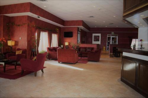 uma ampla sala de estar com paredes e mobiliário vermelhos em Texas Inn & Suites em Denton