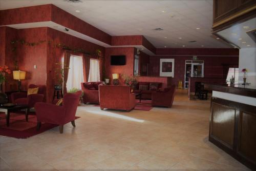 a large living room with red walls and furniture at Texas Inn & Suites in Denton