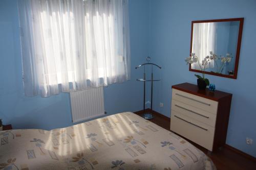 a bedroom with a bed and a dresser and a window at Apartment Jola in Pobierowo