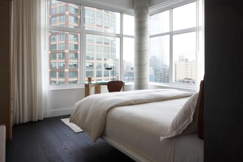 a bedroom with a bed and a large window at WestHouse Hotel New York in New York