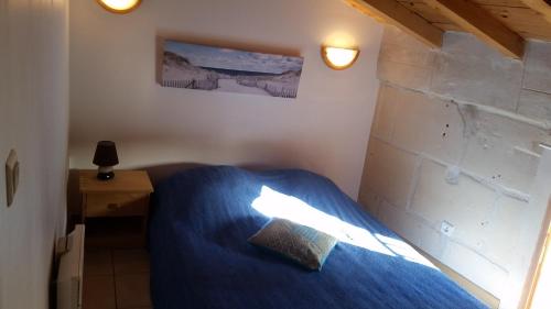 une chambre avec un lit bleu et un mur de briques dans l'établissement Luclem, à Arles