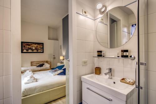 a bathroom with a sink and a bed with a mirror at Vatican Miracle Suite in Rome