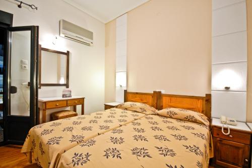 a bedroom with a bed and a dresser and a mirror at Hotel Coronis in Naxos Chora