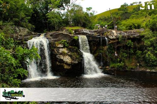 a waterfall in the middle of a pool of water at Atalho Guest House in Cunha