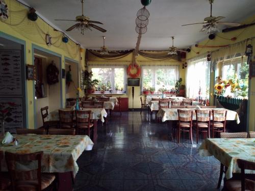 a dining room with tables and chairs and windows at Domki " ELRINO " in Jastarnia