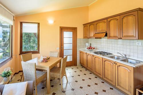 a kitchen with wooden cabinets and a table with chairs at Casa Cinzia in Gravedona