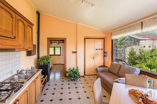 a kitchen and living room with a couch and a table at Casa Cinzia in Gravedona