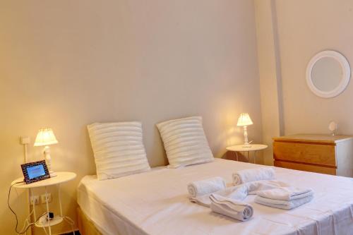 a bedroom with a white bed with towels on it at Fairytale view of Lycabettus in Athens