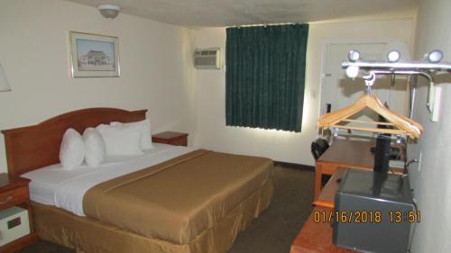 une chambre d'hôtel avec un lit et un appareil photo dans l'établissement Western Inn - Green River, à Green River