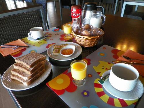 einen Tisch mit einem Frühstück mit Toast, Kaffee und Orangensaft in der Unterkunft Casa del Valle, Lodges in Hinojosas de Calatrava