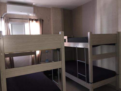 two bunk beds in a room with a mirror at INCRÍVEL Ap a 100m do MAR com Ar e Wi-Fi in Balneário Camboriú