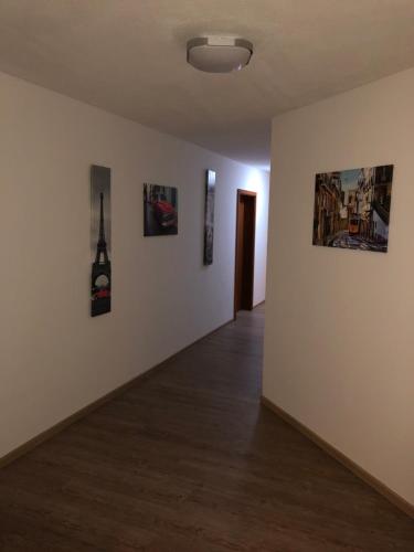 a room with three paintings on the wall and a hallway at Hotel zum Kreidesee, kein Urlaubshotel ! in Hemmoor