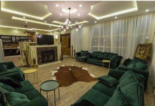 salon z zielonymi meblami i kominkiem w obiekcie شالية النخلة w mieście Unajza