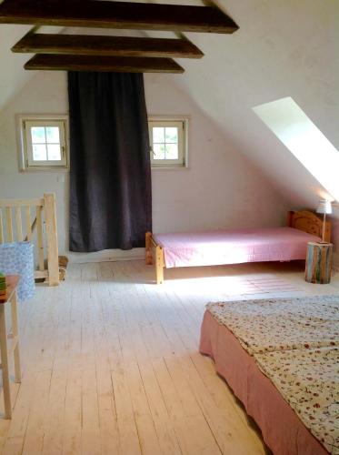 a attic bedroom with a bed and a window at Kopanický dvor in Hodruša