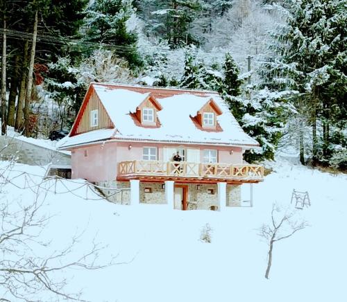 ein Haus mit schneebedecktem Dach im Schnee in der Unterkunft Kopanický dvor in Hodruša