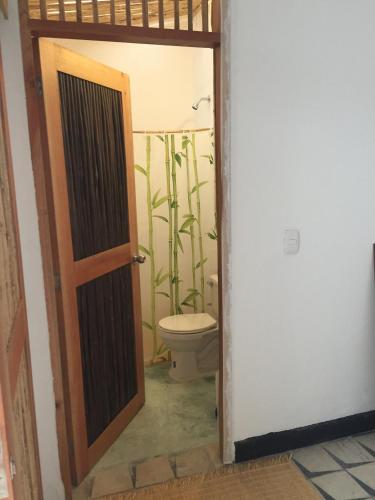 an open door to a bathroom with a toilet at Casa de la tierra in Santa Marta