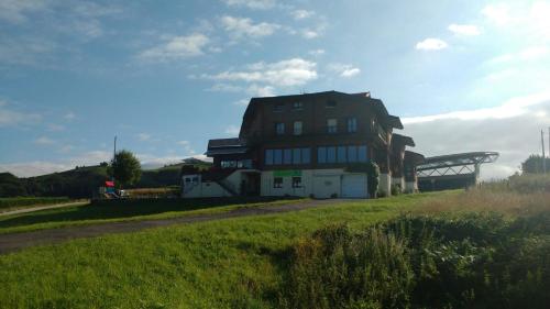 a building on the side of a grass field at Gazteategi in Zarautz