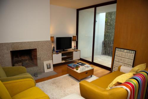 a living room with a yellow couch and a fireplace at Civitá Design & Accommodation in Braga